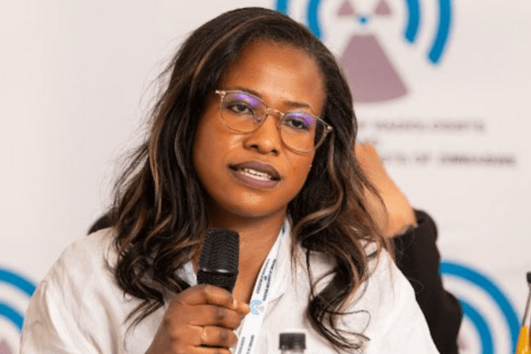 Д-р Каниепи е първата жена каридохирург в Зимбабве тъмнокожа жена лекар с очила, която държи микрофон