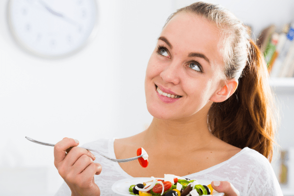 Добавянето на зеленчуци в менюто подобрява сърдечното здраве жена с бяла тениска, която държи чиния със зеленчуци