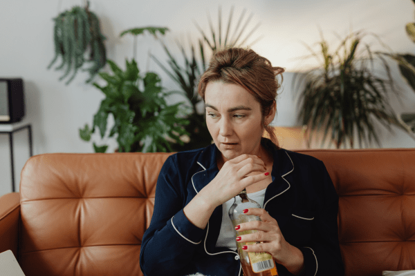 Женският мозък е по-слабо засегнат от алкохола жена с тъмносиня дреха, която държи бутилка с алкохол