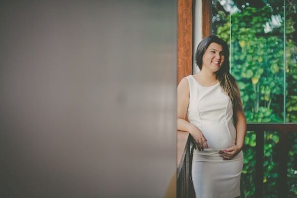 бременна жена в бяла, тясна рокля