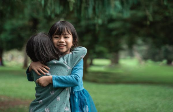Малките деца понякога прекаляват с физическата близост... дете прегръща дете, две деца, момиченца в парка