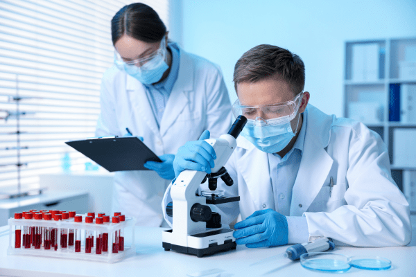 Тройна медикаментозна терапия унищожава раковите клетки при животински модели с левкемия мъж и жена учени в лаборатория