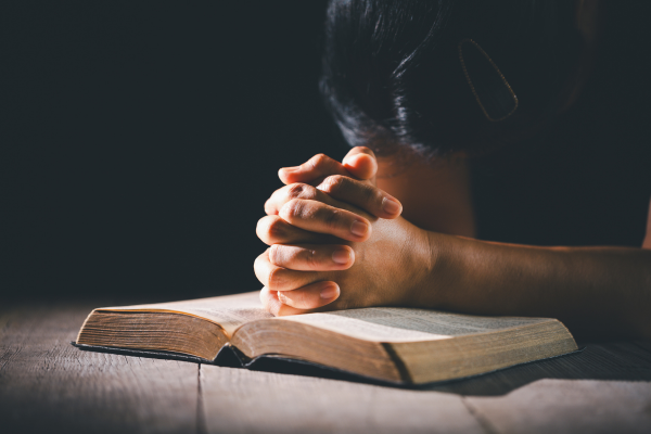 Жените католички често са ставали жертва на сексуален тормоз в изповедалнята, сочат исторически документи жена, сключила ръце в молитва над книга