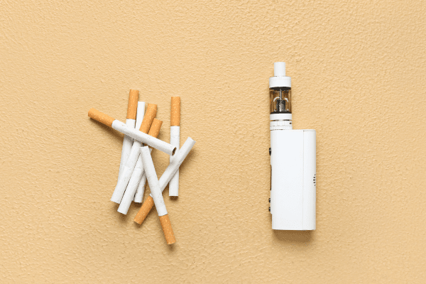Използвайте вейп с ниска концентрация на никотин вейп и обикновени цигари на оранжев фон