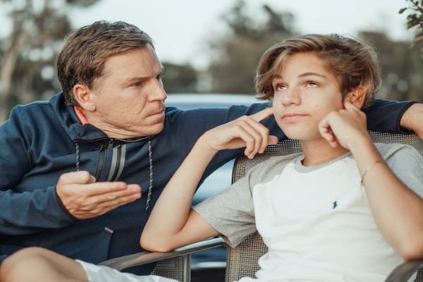 Мъж се опитва да разговаря с тийнейджър, който е запушил ушите си