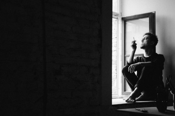 Силното напрежение и самообвиненията повишават риска от саморазрушително поведение мъж пуши до прозорец