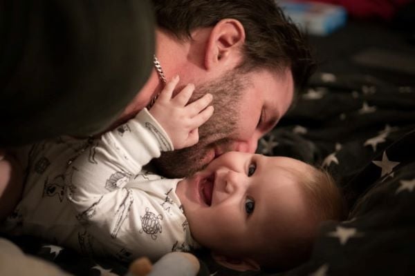 баща целува бебе