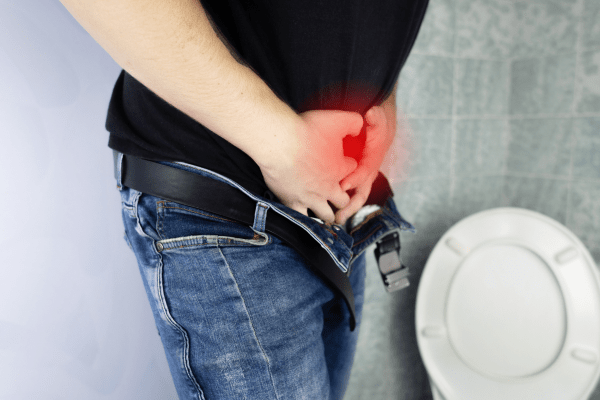 Лазерна процедура предлага трайно решение, без болка, на мъжете с уголемена простата мъж с черна тениска в тоалетна, който се държи за слабините