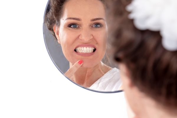 Лицевите упражнения могат да подобрят вида ви жена прави лицеви упражнения пред огледало