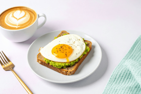 Закуската за ден шести от менюто против стрес се състои от филия хляб, яйце и авокадо. филия хляб с яйце и авокадо