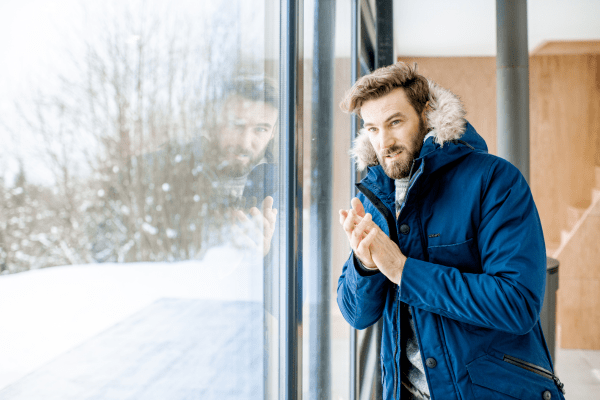 Не е вярно, че човек губи най-много топлина през главага си мъж с брада и синя парка, който трие дланите си