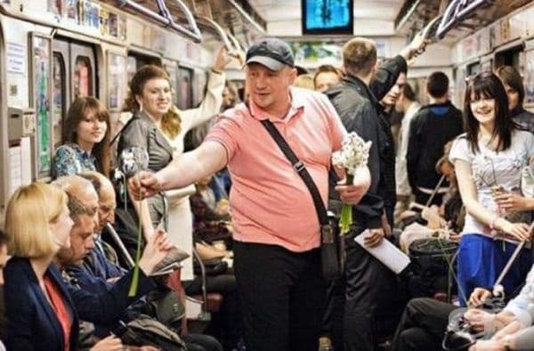 Този мъж дава цветя на всички жени в метрото.